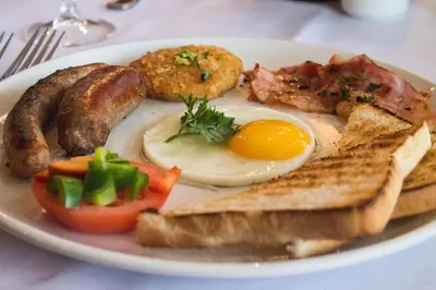 a plate of breakfast food with eggs sausage and toast at Little Pilgrims Boutique Hotel in Hazyview