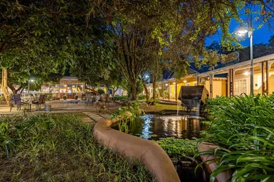 a pond in the middle of a park at night at Little Pilgrims Boutique Hotel in Hazyview
