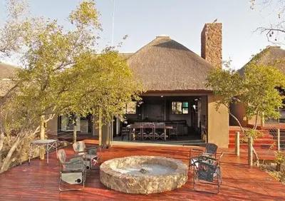 a large patio with a building with a fire pit at Feeskraal Lodge in Moheme