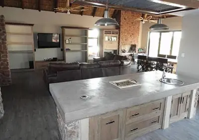 a large kitchen and living room with a counter top at Feeskraal Lodge in Moheme