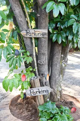 a tree with signs that say gardening and parking at La Frans Guesthouse in Pretoria
