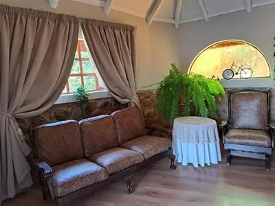 a living room with a couch and two chairs at La Frans Guesthouse in Pretoria