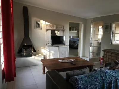 a living room with a table and a fireplace at Leopard Tree Retreat in Nelspruit