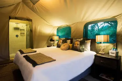 a bedroom with a large bed in a tent at Camp Bethel in Hoedspruit