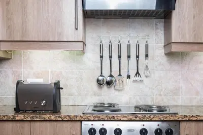 a kitchen with a stove and utensils on the wall at Kruger Park Lodge Unit No. 277 in Hazyview
