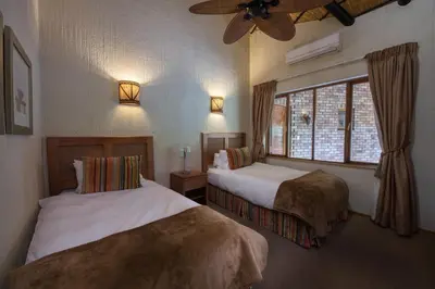 a hotel room with two beds and a window at Kruger Park Lodge Unit No. 277 in Hazyview