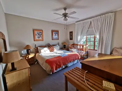 a bedroom with a bed and a couch and a window at Meintjieskop Self-Catering Accommodation in Pretoria