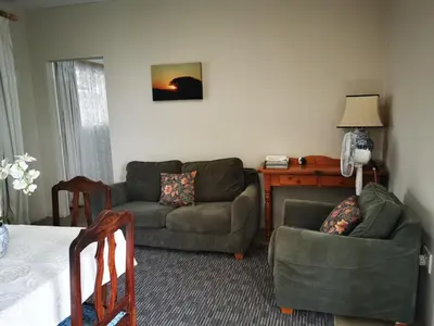 a living room with a couch and two chairs and a table at Meintjieskop Self-Catering Accommodation in Pretoria