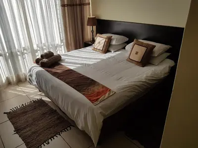a large bed with pillows on it in a bedroom at 360 Eastwoods Guesthouse in Pretoria