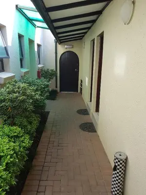 a hallway of a building with a black door at 360 Eastwoods Guesthouse in Pretoria