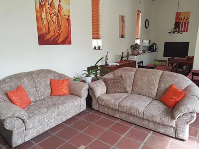 a living room with two couches and a tv at 360 Eastwoods Guesthouse in Pretoria