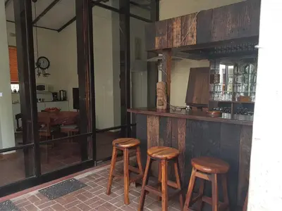 a bar with three wooden stools in a room at 360 Eastwoods Guesthouse in Pretoria