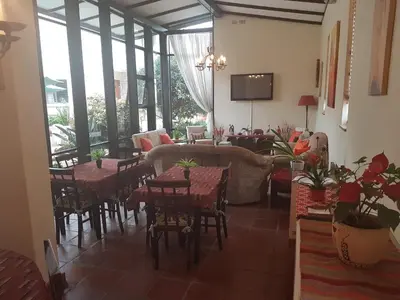 a dining room with tables and chairs and windows at 360 Eastwoods Guesthouse in Pretoria