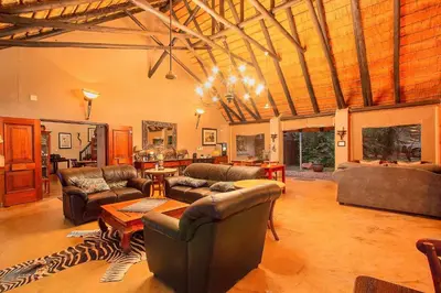 a large living room with couches and a table at Mvuradona Safari Lodge in Marloth Park