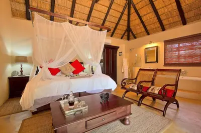a bedroom with a bed with a canopy at Mvuradona Safari Lodge in Marloth Park