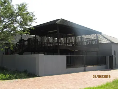 a building with a black roof and a fence at Vido Lodge and Conference Centre in Polokwane