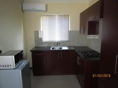 a small kitchen with a sink and a microwave at Vido Lodge and Conference Centre in Polokwane