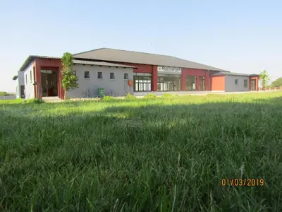 a building with a grass field in front of it at Vido Lodge and Conference Centre in Polokwane