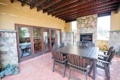 a wooden table and chairs on a patio at Catmandu in Dullstroom