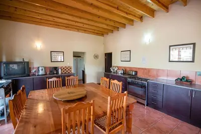 a large kitchen with a wooden table and chairs at Catmandu in Dullstroom