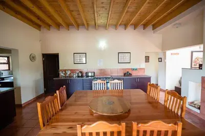 a dining room with a table and a kitchen at Catmandu in Dullstroom