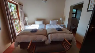a bedroom with a large bed and a window at Catmandu in Dullstroom