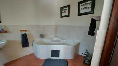 a bathroom with a tub in the corner of a room at Catmandu in Dullstroom