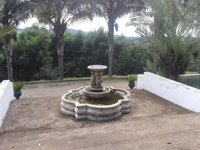 a stone fountain in a courtyard with palm trees at Sherwood's Country House in Tzaneen