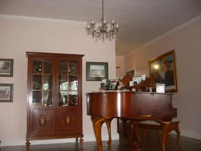 a room with a piano and a chandelier at Sherwood's Country House in Tzaneen
