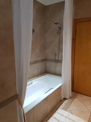 a bath tub in a bathroom with a shower at Bubez Guesthouse in Barberton