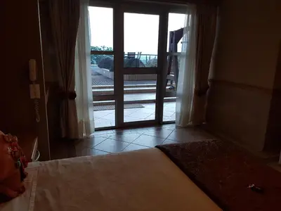 a bedroom with a bed and a sliding glass door at Bubez Guesthouse in Barberton