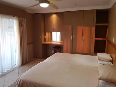 a bedroom with a large white bed and a window at Bubez Guesthouse in Barberton