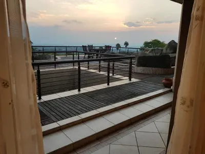 a balcony with a table and a view of the ocean at Bubez Guesthouse in Barberton