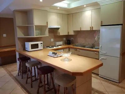 a kitchen with a wooden counter top with a microwave at Bubez Guesthouse in Barberton