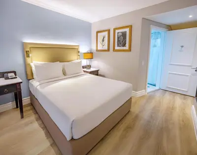 a bedroom with a large white bed and a desk at Southern Sun Mbombela in Nelspruit