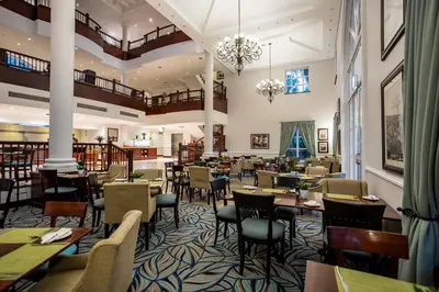 a restaurant with tables and chairs in a room at Southern Sun Mbombela in Nelspruit