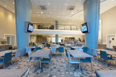 a restaurant with blue tables and blue chairs at StayEasy Mbombela in Nelspruit