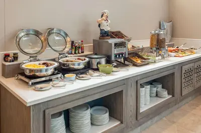 a breakfast buffet with dishes and food on a counter at StayEasy Mbombela in Nelspruit