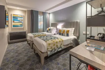 a hotel room with two beds and a table at StayEasy Mbombela in Nelspruit