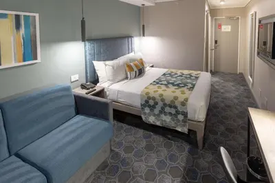 a hotel room with a bed and a chair at StayEasy Mbombela in Nelspruit