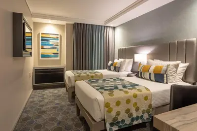 a hotel room with two beds and a table at StayEasy Mbombela in Nelspruit