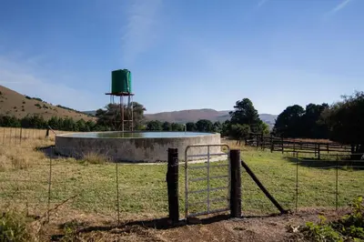 a fence in a field with a pond in the middle at Spitskop Plaashuis in Lydenburg