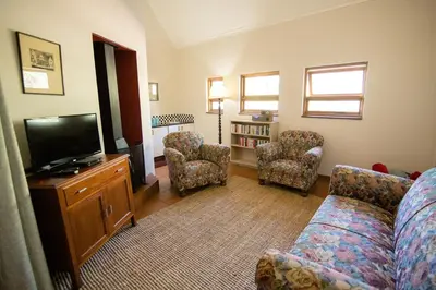 a living room with a couch and a flat screen tv at Spitskop Plaashuis in Lydenburg