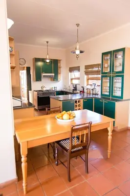 a kitchen with a wooden table with a bowl of fruit on it at Spitskop Plaashuis in Lydenburg
