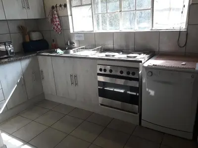 a white kitchen with a stove and a sink at African Sky in Marloth Park