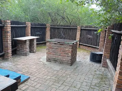 a brick patio with a table and a fence at African Sky in Marloth Park
