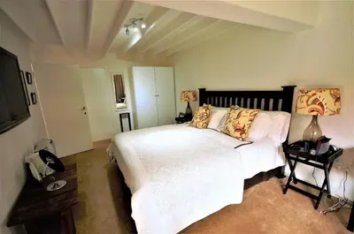 a bedroom with a white bed and a flat screen tv at Galashiels in Dullstroom