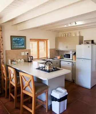 a kitchen with a white refrigerator and a table with chairs at Galashiels in Dullstroom
