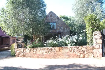 a house with a stone fence and a stone wall at Galashiels in Dullstroom