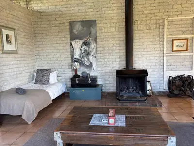 a living room with a bed and a fireplace at Green Thumb Farm Stay in Ermelo